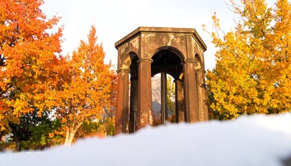 Autumnal foliage surrounds a weathered stone gazebo.