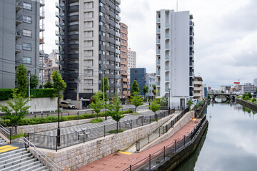 Modern high-rise residential apartments, riverside walkway along the riverbank of Hori River in Nagoya, Japan. Concept of waterfront living, Japanese cityscape, and everyday neighborhood environment © Doublelee