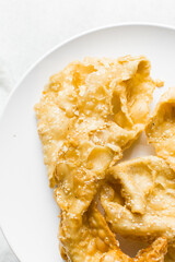 Overhead view of dublan northern nigerian snack, top view of dublan on a plate, flaky fried dough coated in syrup and sesame