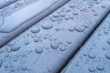 Close-up of thick water droplets on a textured wooden surface conveying tranquility and freshness