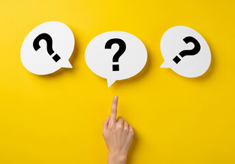 Hand pointing to three white speech bubbles with question marks on yellow background