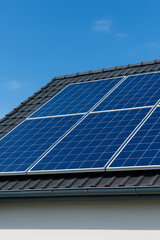Fototapeta premium Solar Panels Installed on Modern House Roof Under Clear Blue Sky