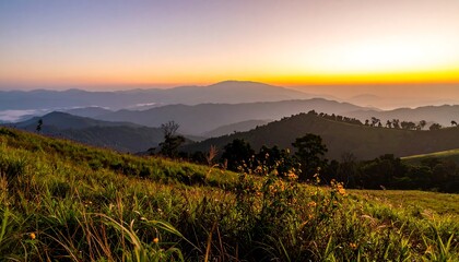 A serene mountain vista at sunrise, showcasing layered hills and a blanket of mist.