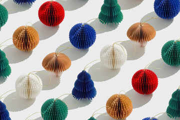 Colorful Paper Christmas Ornaments as round balls and Christmas trees, hanging eco-friendly New Year decorations. Minimal aesthetic holidays pattern, top view background of winter baubles.
