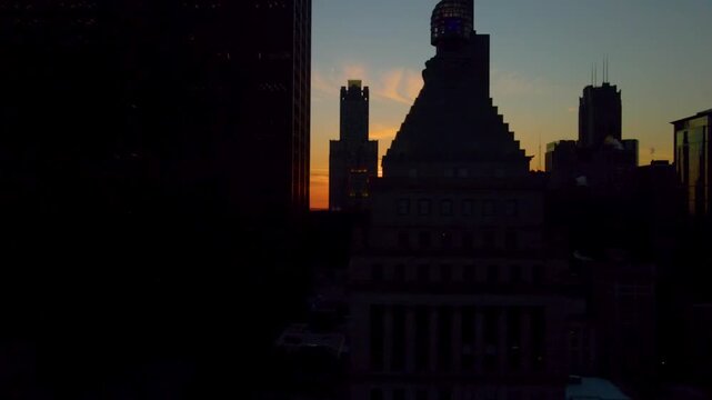 Drone shot of Chicago Henge sunset with the sun aligned behind the skyline silhouette, glowing against a deep blue and orange sky over the city.