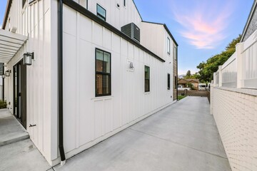 Modern white house exterior at sunset.