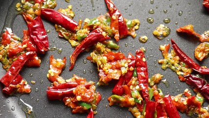 Pan-fry the fresh and dried chilies with a spatula in a hot pan.