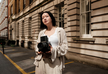 Young photographer holding medium format camera in urban setting