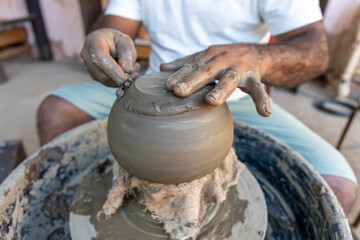 Afro-Brazilian man, third generation of a family of potters, crafting clay pieces inspired by ancient Tapajonic art to preserve cultural tradition in Santarem, Para, Brazil