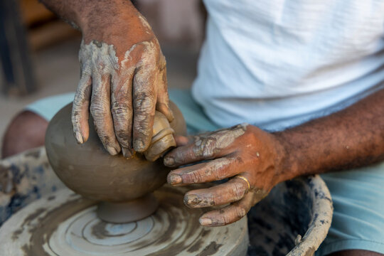 Afro-Brazilian man, third generation of a family of potters, crafting clay pieces inspired by ancient Tapajonic art to preserve cultural tradition in Santarem, Para, Brazil