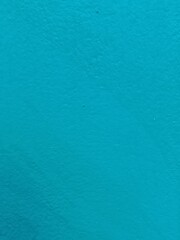 Close up of a blue painted wall with a rough texture for backgrounds and designs