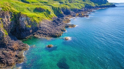 Scenic coastline featuring rocky shore and turquoise waters under a clear blue sky in a tranquil natural setting