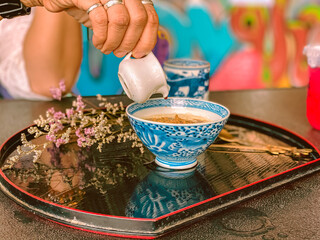 A hand is pouring rich, sweet sauce over a delicious Japanese dessert. The glossy sauce slowly drizzles and coats the surface of the treat, adding a fragrant sweetness and an irresistible glossy finis