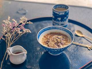 A hand is pouring rich, sweet sauce over a delicious Japanese dessert. The glossy sauce slowly drizzles and coats the surface of the treat, adding a fragrant sweetness and an irresistible glossy finis