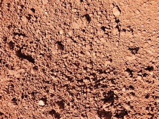 close-up of the texture and color of the reddish-brown clay or laterite surface.