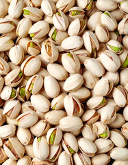 Fototapeta premium A close-up of a group of shelled and unshelled pistachio nuts, some with green, healthy seeds