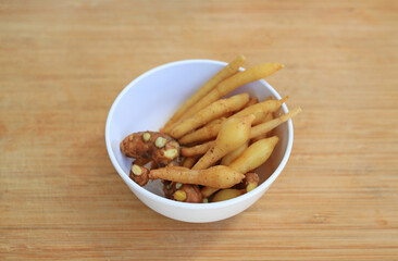 Finger root or Chinese ginger on bamboo wooden background, preparation process for cooking.