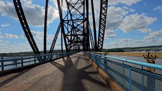 POV cycling across the historic Old Chain of Rocks Bridge (Route 66) over the Mississippi River near St. Louis, Missouri. Scenic ride with sweeping river views, unique bridge design.