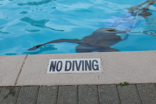 A black man swimming under water in a pool 