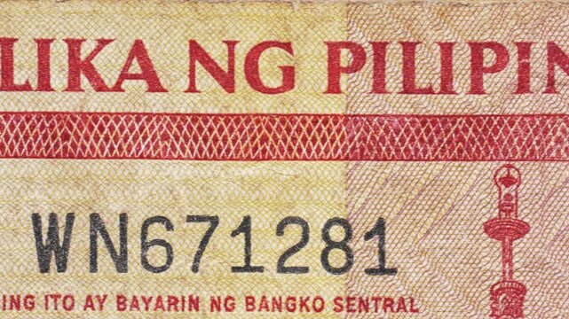 Macro pan over Filipino &ldquo;Republika ng Pilipinas&rdquo; text on a Philippine peso note