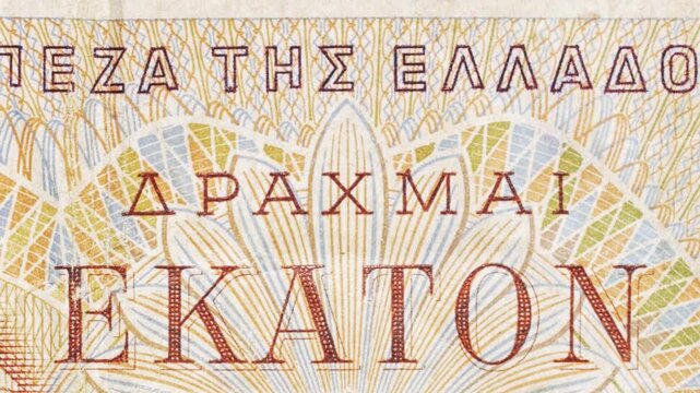 Close-up pan across Greek &ldquo;Bank of Greece&rdquo; lettering and guilloche on a drachma note