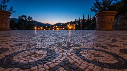 Mosaic floor with illuminated town lights at twilight