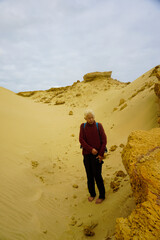 A woman walking on the Giant Sand Dunes, Cape Reinga, New Zealand.