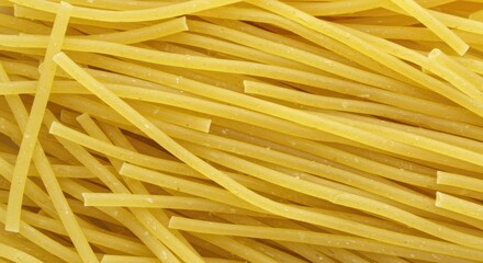 Close-up of uncooked spaghetti pasta, textured yellow food background.