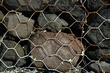 Large Boulders Behind Metal Mesh Netting © Юрий Несмашный