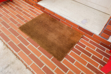 Welcome mat on red brick floor,Overhead of blank doormat at the front door,office or home,space for text.