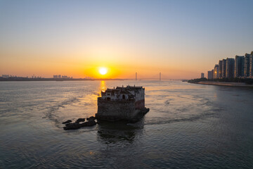 Obraz premium Historic building in Yangtze River catches bright sunset light near Ezhou City, Hubei Province, China.