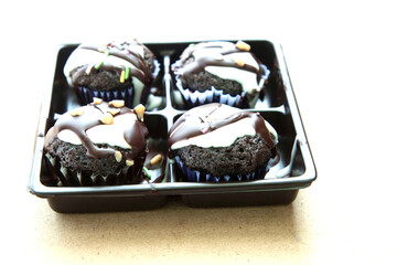 This dark brown brownie topped with chocolate and nuts makes it even more appetizing on the light brown wood floor, shot in the morning in natural light from above.