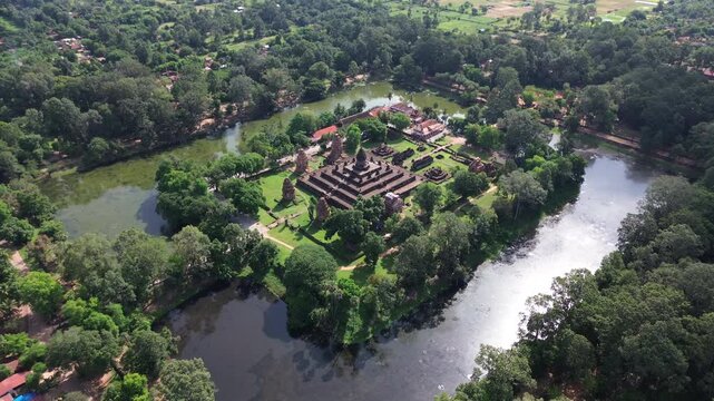 Aerial establishing orbit of Bakong Temple ruins surrounded by lush jungle near Siem Reap, Cambodia