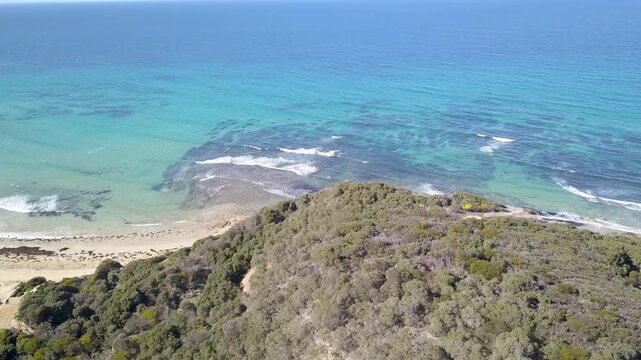 Drone aerial of Victoria&rsquo;s Great Ocean Road, revealing spectacular ocean cliffs, vibrant turquoise waters, and lush forest lining the scenic coastline - DLOG Flat File 4K