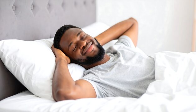 Smiling african american man relaxing in comfortable bed at home with eyes closed and hands behind head, feeling refreshed and peaceful. - Powered by Adobe