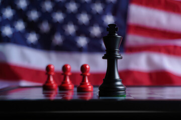 Naklejka premium American king chess piece stands tall against red pawns with flag