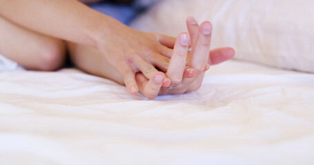 Couple, holding hands and relax with comfort in bed for love, support or trust together in home. Closeup, people or touch with commitment for relationship, physical connection or bonding on space
