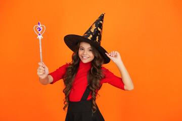Halloween costume party. All Hallows witch girl. Girl in witch costume hold magic wand. Happy...