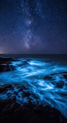 Fototapeta premium Bioluminescent Waves Crashing on Rocky Coastline under Starry Night Sky