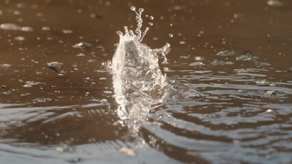 Slow motion of fishing line and bait in river water at golden hour, snapping tight and creating splashes and ripples when fish bites