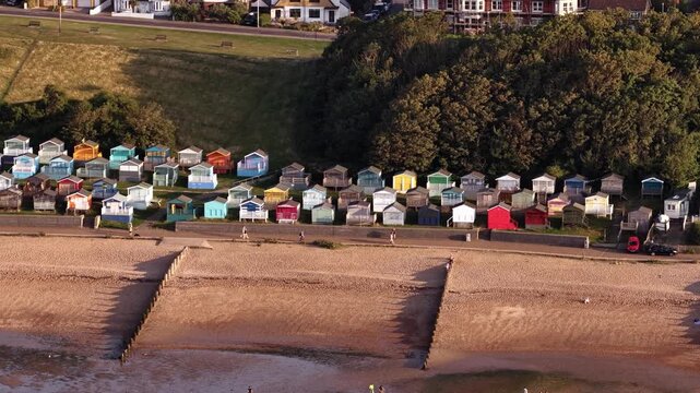 Scenic beach huts line Whitstable's sandy shore, evoking serene coastal vibe