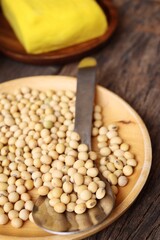 Soybeans and yellow tofu on wood background