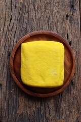 Soybeans and yellow tofu on wood background