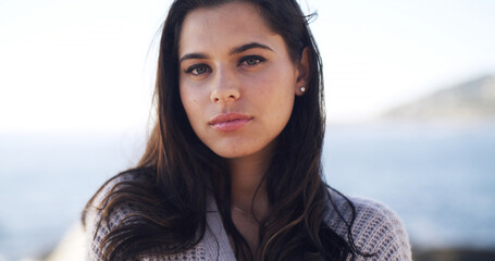 Portrait, travel and woman at sea for vacation, summer trip and adventure in nature. Beach, tourist and serious person outdoor with confidence on holiday break at ocean on island in Australia