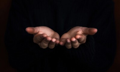 Two hands cupped together on a black background, creating a sense of offering, receiving, or requesting