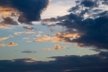 Vibrant clouds paint the evening sky in a beautiful blend of orange, red, and yellow light