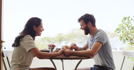 Breakfast, holding hands and laughing with couple on balcony of home together for bonding. Funny, love and morning with happy people outdoor at apartment for anniversary, honeymoon or romance