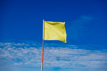 Yellow Flag Against Clear Blue Sky
