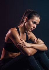 Naklejka premium Woman with crossed arms in sweaty post-workout state during fitness session break. Intense training recovery content for sports facility advertising campaigns