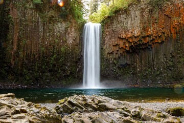 Fototapeta premium Waterfall cascading into serene pool